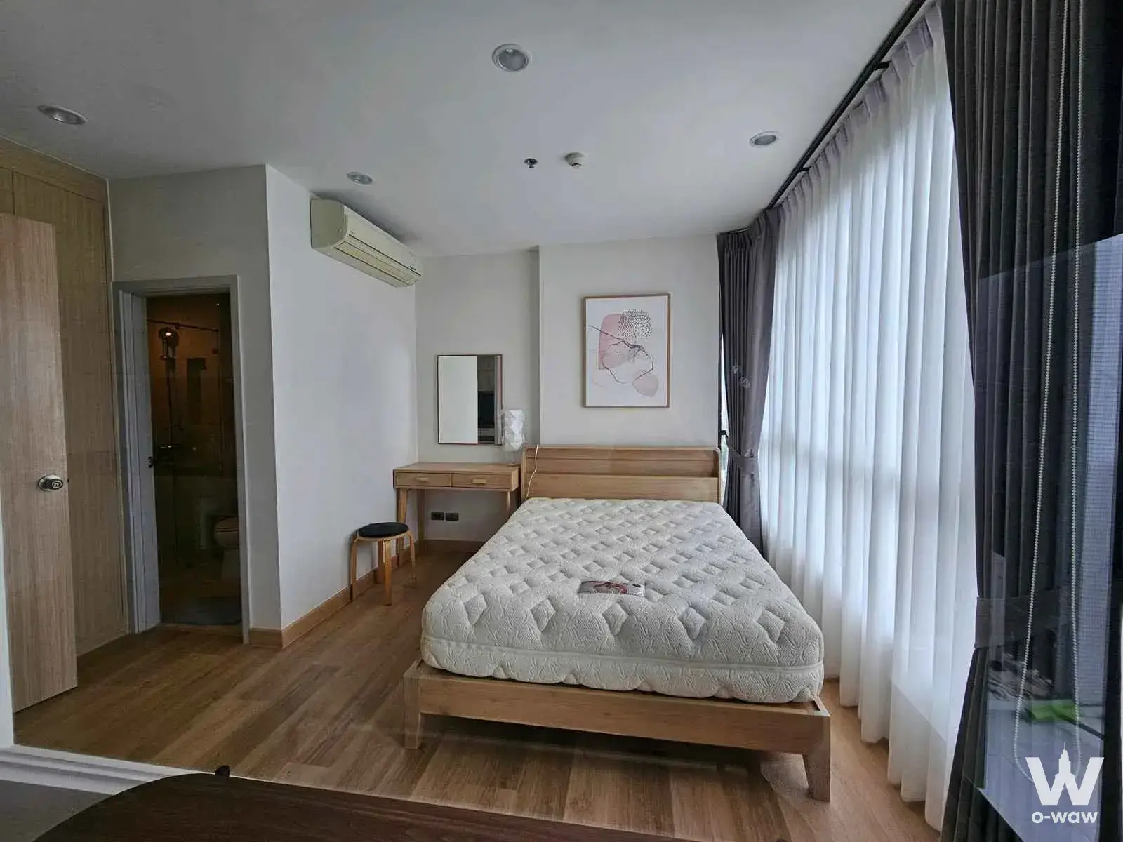 Semi-furnished master bedroom in Fuse Sathon-Taksin with light wood flooring, queen bed, and floor-to-ceiling windows