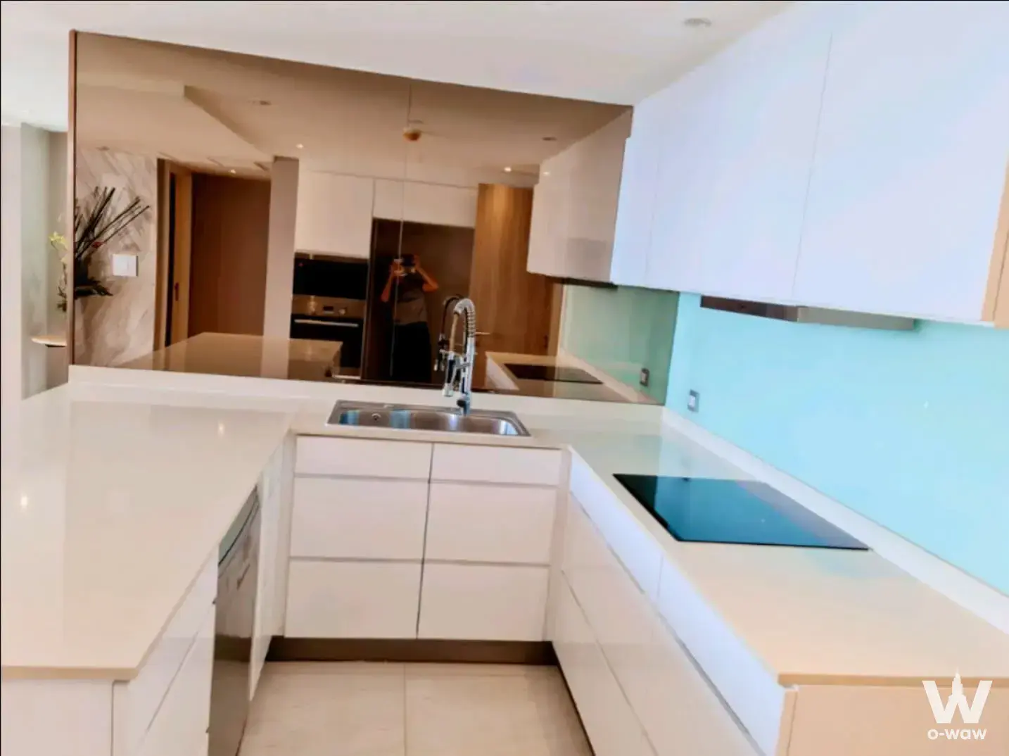 Modern H Sukhumvit 43 kitchen with white glossy cabinets, turquoise backsplash, and stainless steel appliances
