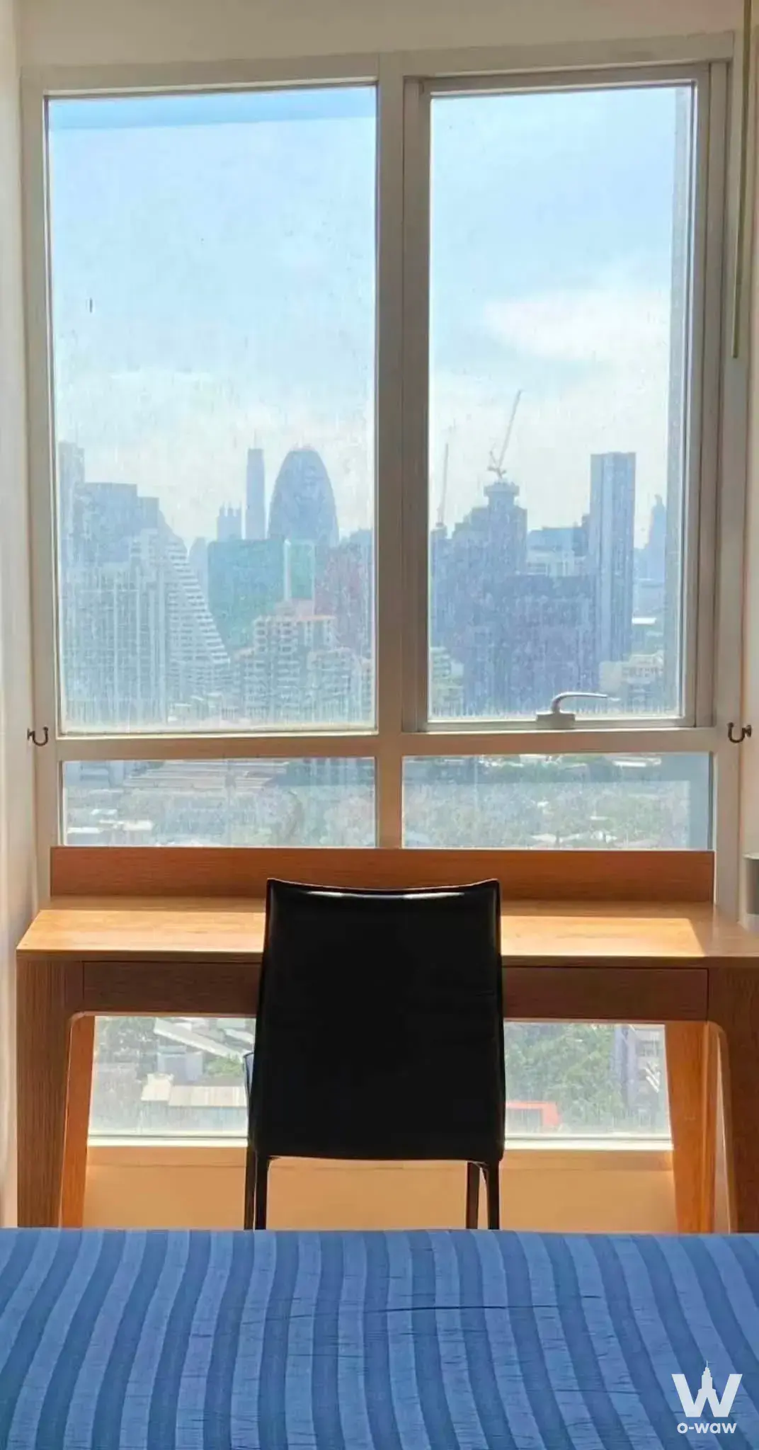 Bedroom corner in Rhythm Phahon-Ari with a built-in desk and high-floor city skyline views
