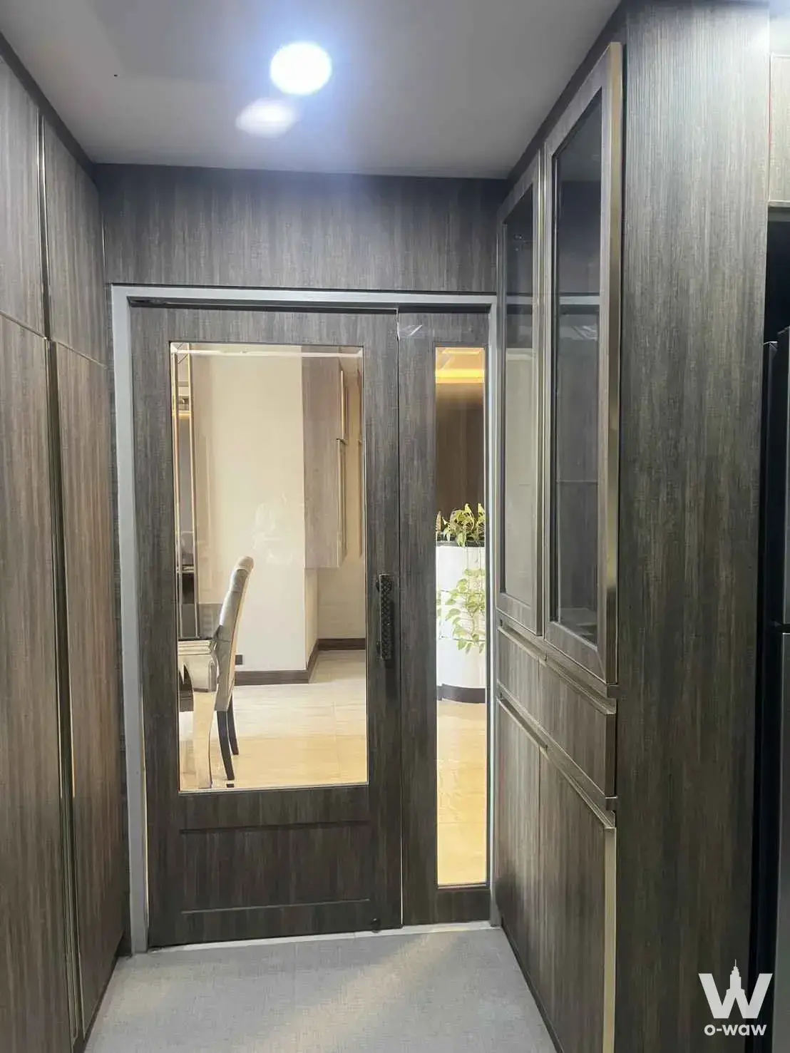 Entryway corridor in a Park24 3-bed rental with dark grey wood paneling and built-in cabinetry