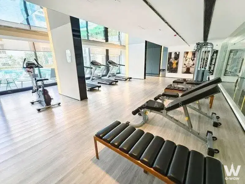 Fully equipped gym in Regal Srinakarin 40 condo featuring treadmills, exercise bike, mirrors, and pool view