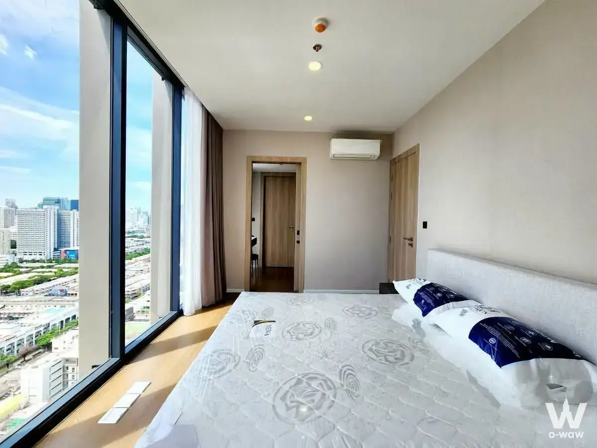 High-floor bedroom in Cooper Siam condo featuring city views and light oak flooring