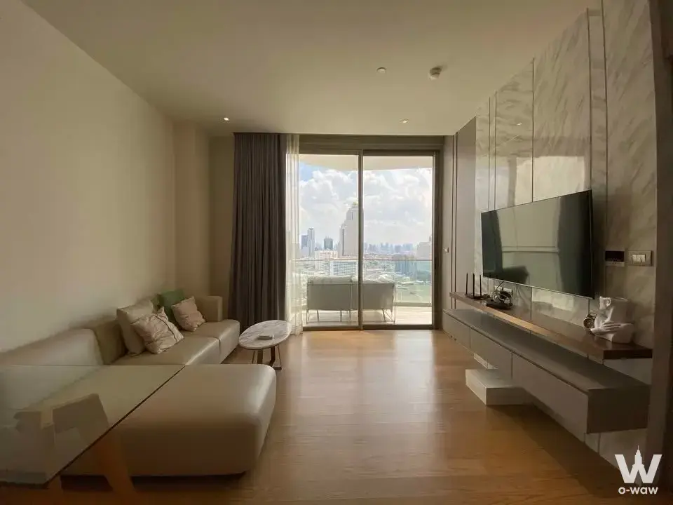 Living room in a 1-bed Magnolias Waterfront condo with cream sectional, marble coffee table and high-floor skyline view