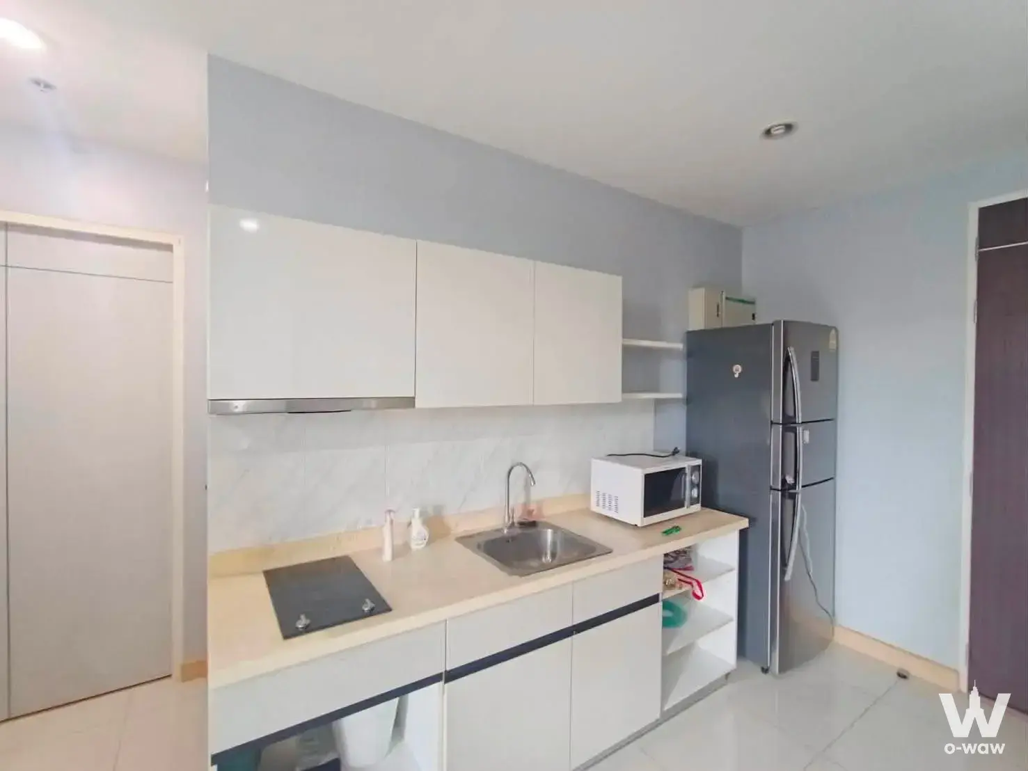 Kitchen in The President Condo Sukhumvit 81 featuring white cabinets, marble backsplash, and stainless steel appliances