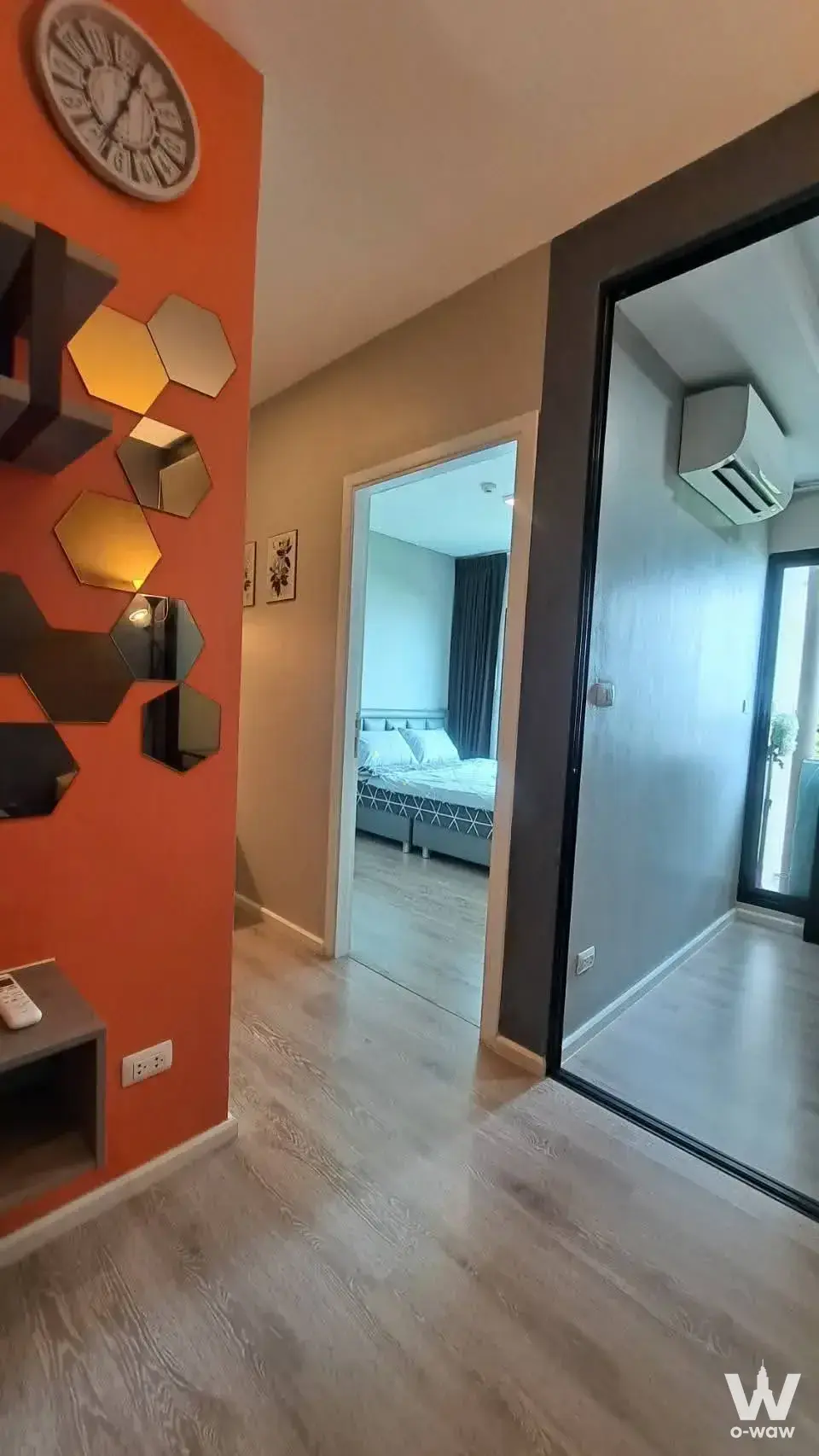 Orange accent wall and bedroom glimpse in a Kensington Sukhumvit-Thepharak rental condo