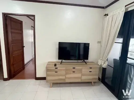 Living room with oak media console and sliding glass door in Aree Place Sukhumvit 26