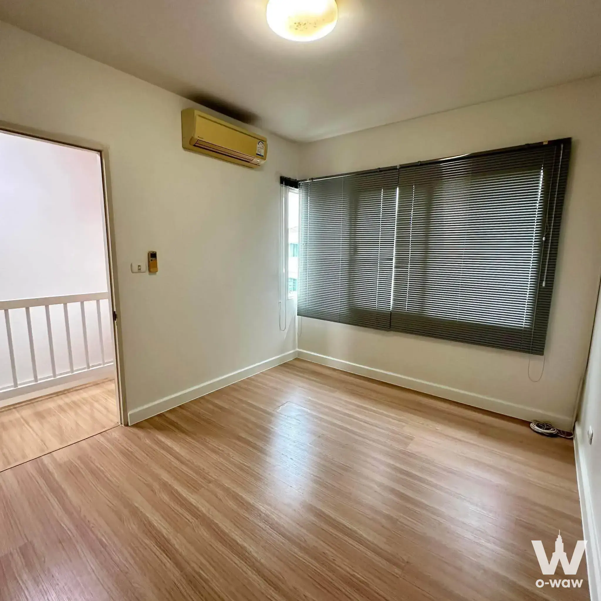 Empty 3-bed townhouse room in Moo Ban Town Plus with light wood floors and balcony access