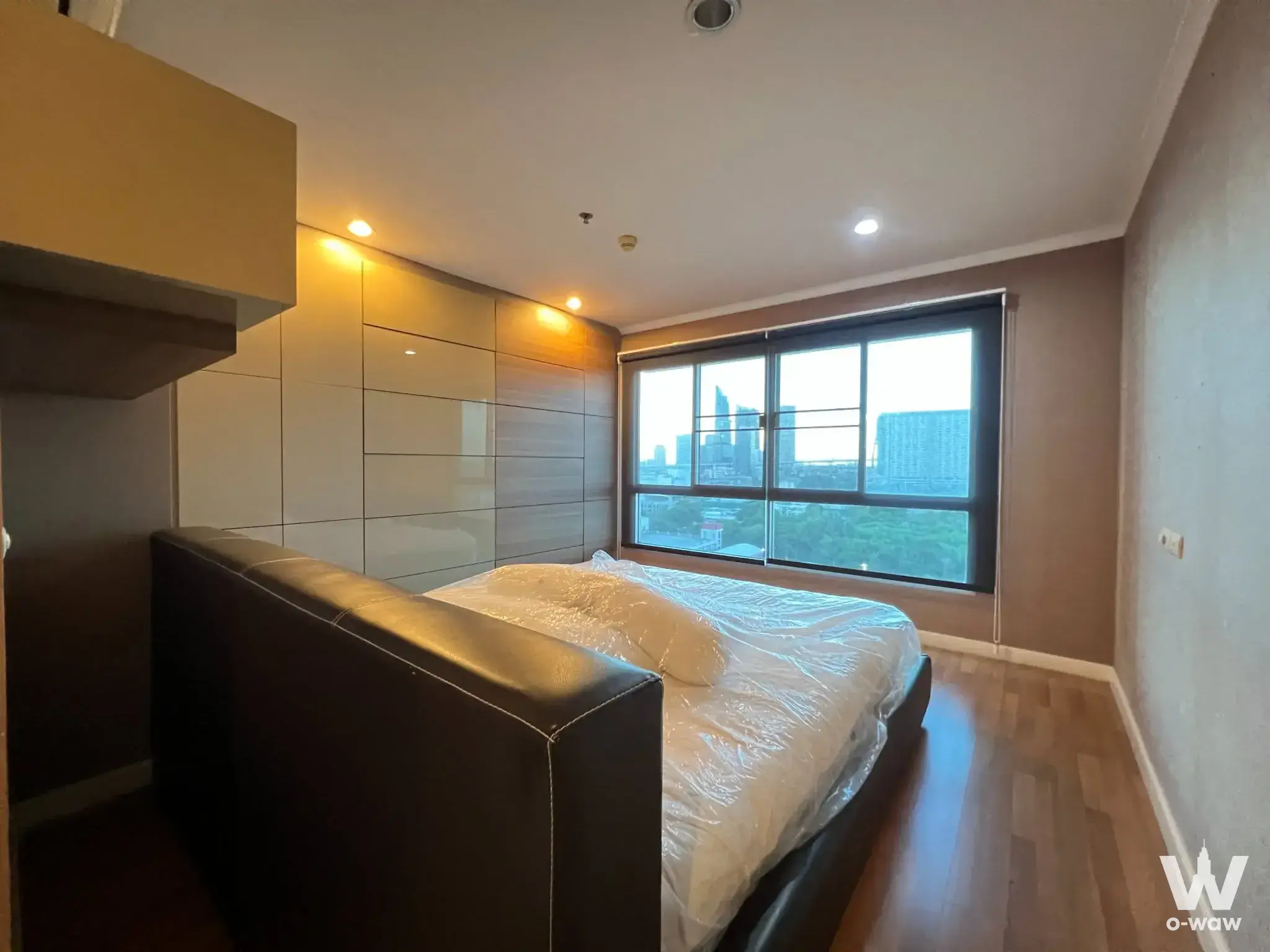 New bedroom in Lumpini Park Riverside Rama 3 featuring a leather bed, glossy wardrobe, and large window with city views