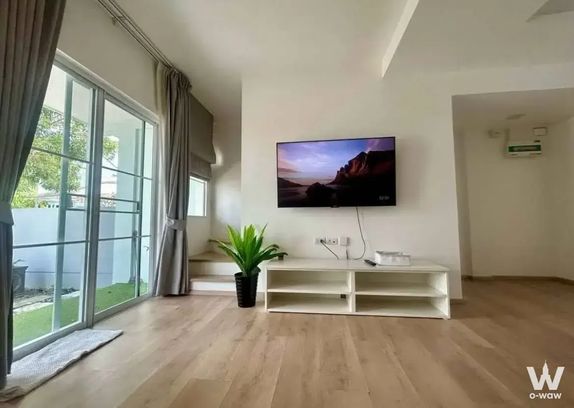 Bright living room in a 2-bed townhouse for rent at Indy 2 Bangna-Ramkhamhaeng 2 with wood floor and black TV