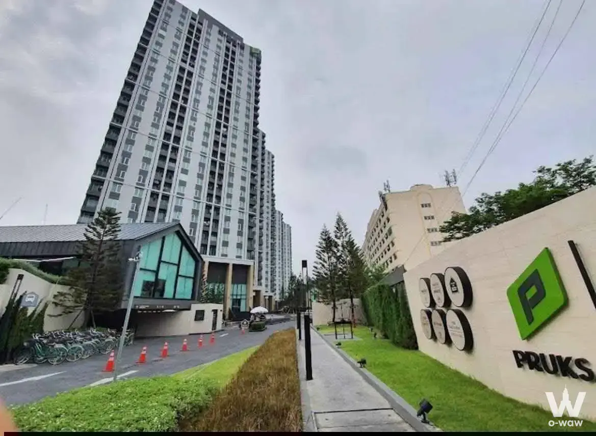 Grey high-rise exterior of Chapter One Eco Ratchada-HuaiKhwang with teal glass gatehouse