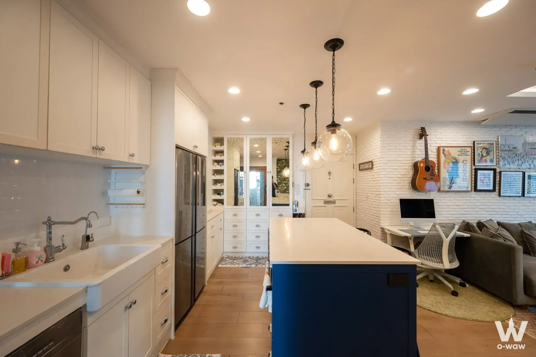 1-bed condo for sale in Belle Grand Rama 9 with open-plan kitchen, blue island, and eclectic modern decor