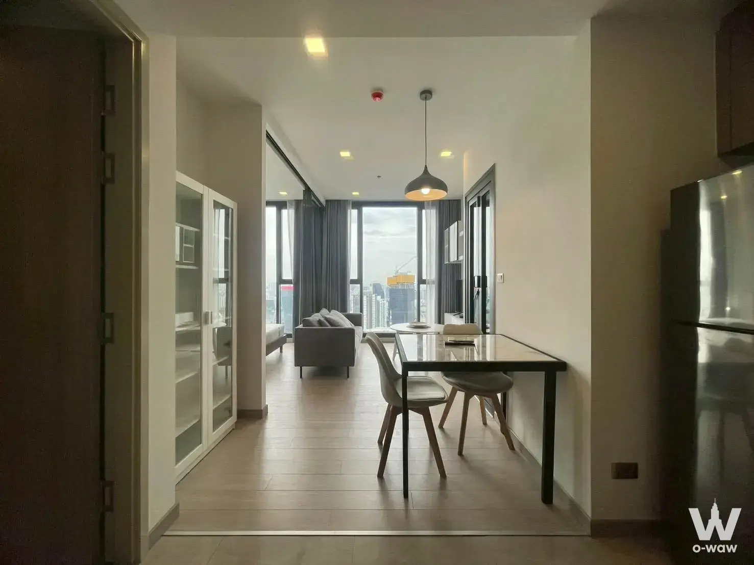 One9Five Asoke 1-bed condo living area with grey sofa, city skyline view and modern furnishings