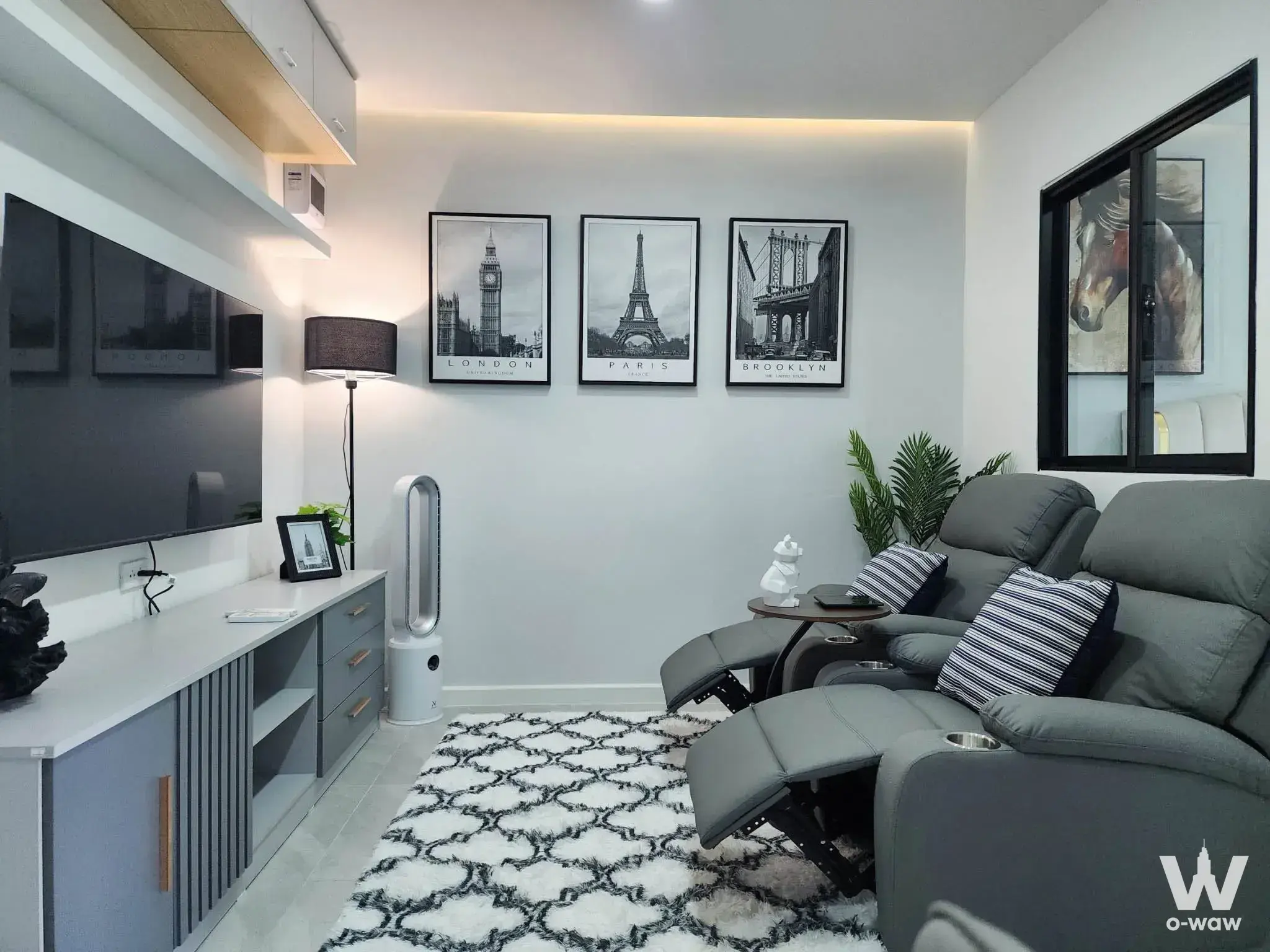 Living room in The Parkland Srinakarin Lakeside condo featuring a grey leather recliner and wall-mounted TV