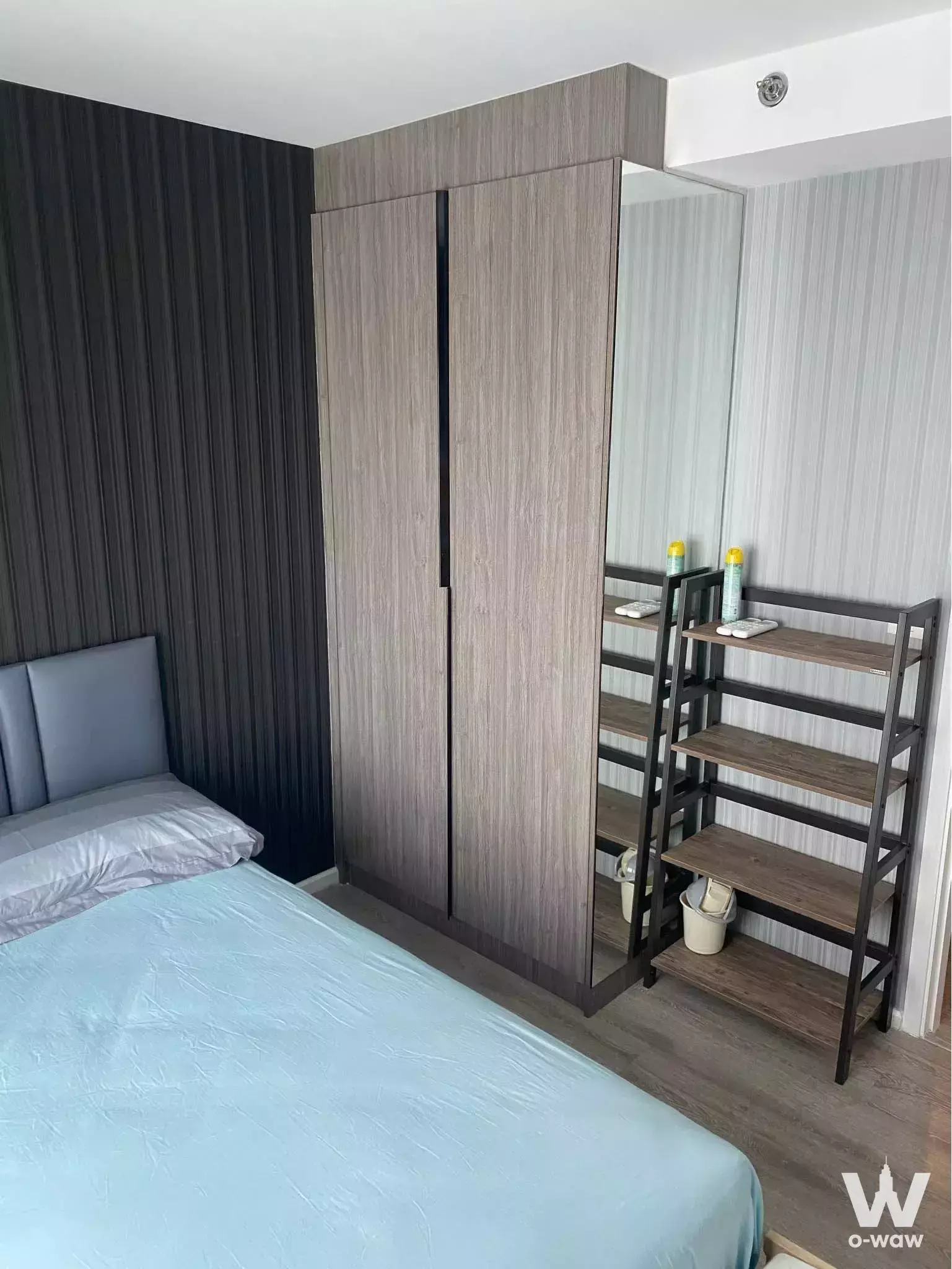Bedroom featuring a charcoal slat accent wall and tall wardrobe in Kensington Sukhumvit-Thepharak