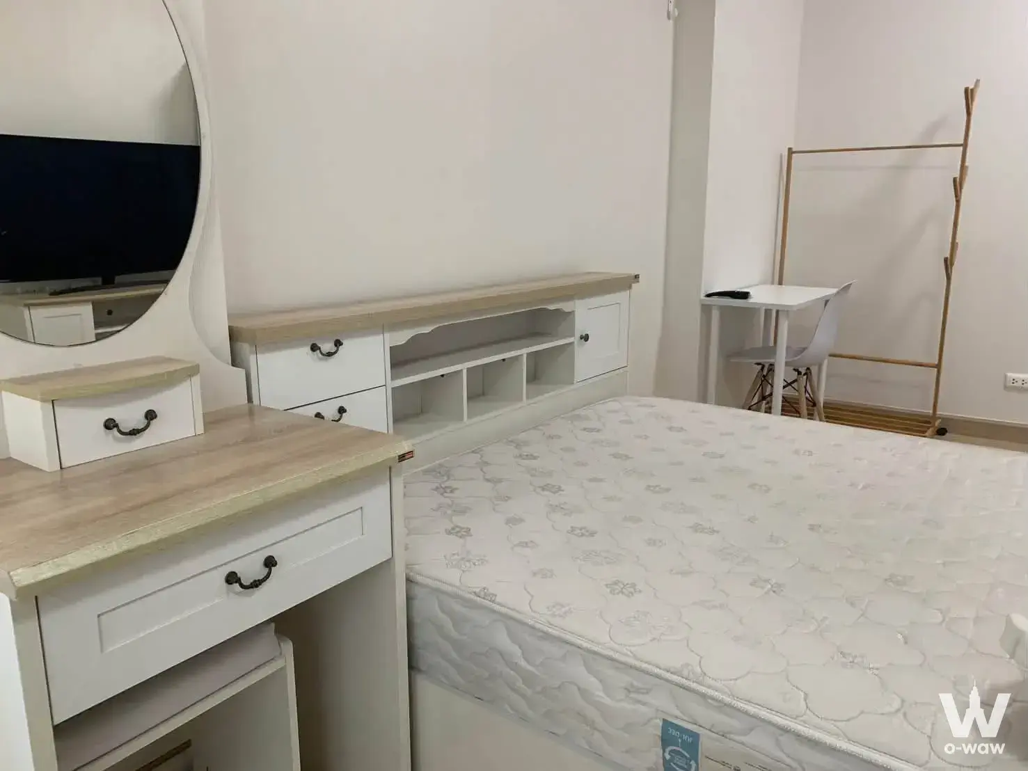 Minimalist bedroom with white vanity desk and media console in this 1-bed condo for rent at Supalai Veranda Rama 9