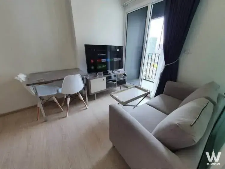 Grey sofa and glass coffee table in the living room of Chapter One Eco Ratchada-HuaiKhwang