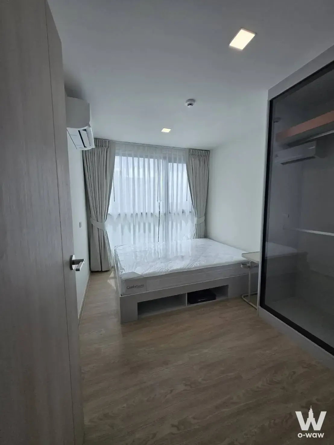Modern bedroom featuring a platform bed and walk-in closet in a 1-bed condo for rent at Kave Luminous Bangmod