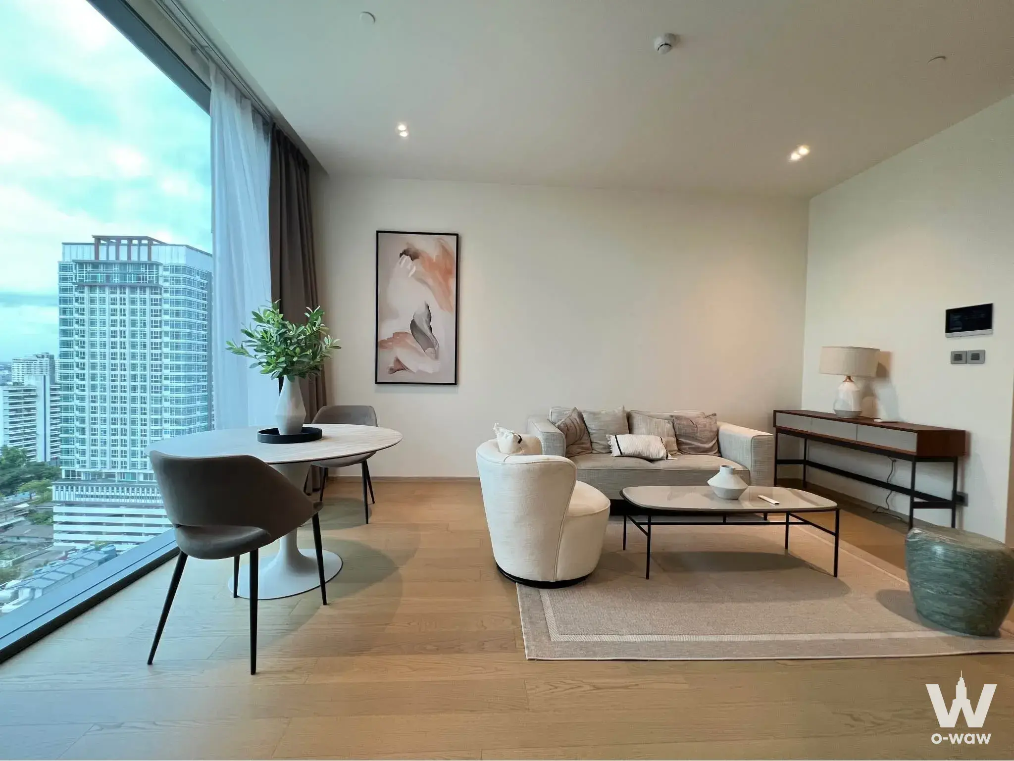 Living room in The Strand Thonglor condo featuring marble dining table and city skyline view