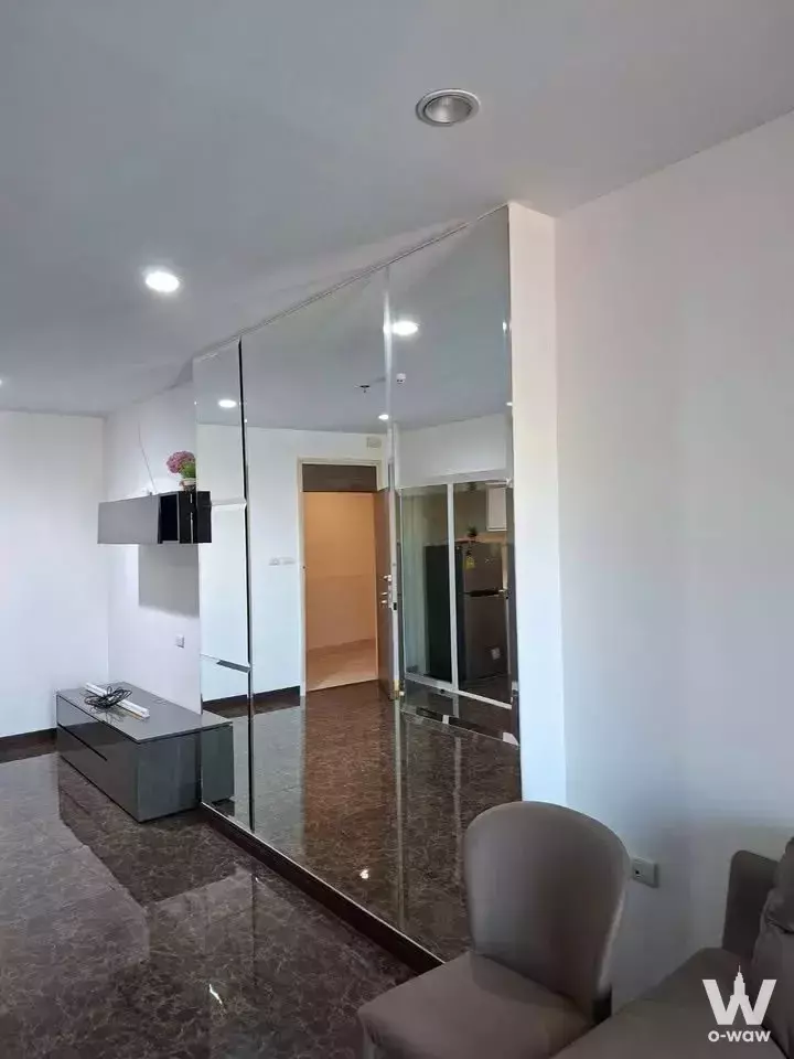 Living room in a Supalai Prima Riva 1-bed condo with glossy marble floors and mirrored sliding wardrobe doors