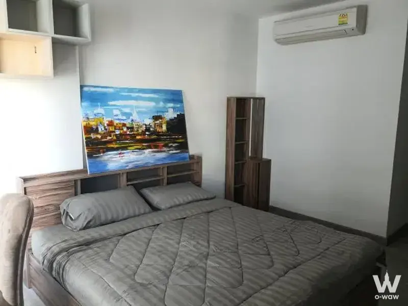 Modern 1-bed bedroom for rent in The Vertical Aree with city skyline art and wood tones