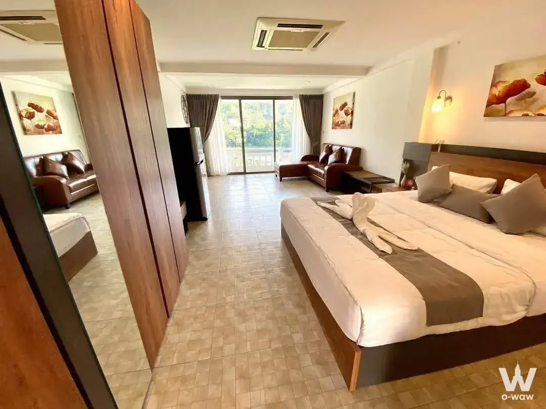 Master bedroom in The Green Golf Residence featuring king bed, dark wood frame, and floor-to-ceiling mirror