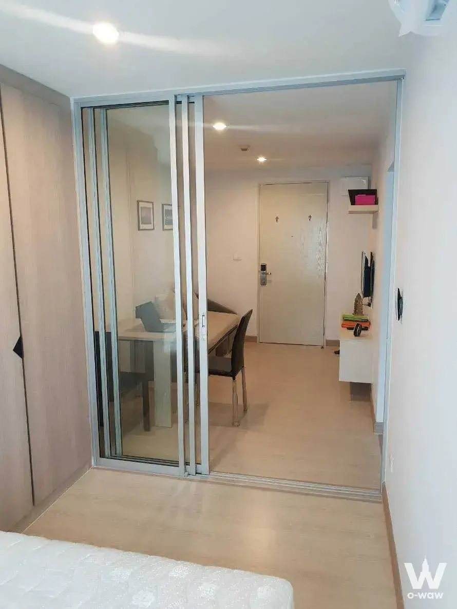 Studio bedroom in The Kith Plus Sukhumvit 113 with glass partition separating sleeping and living areas