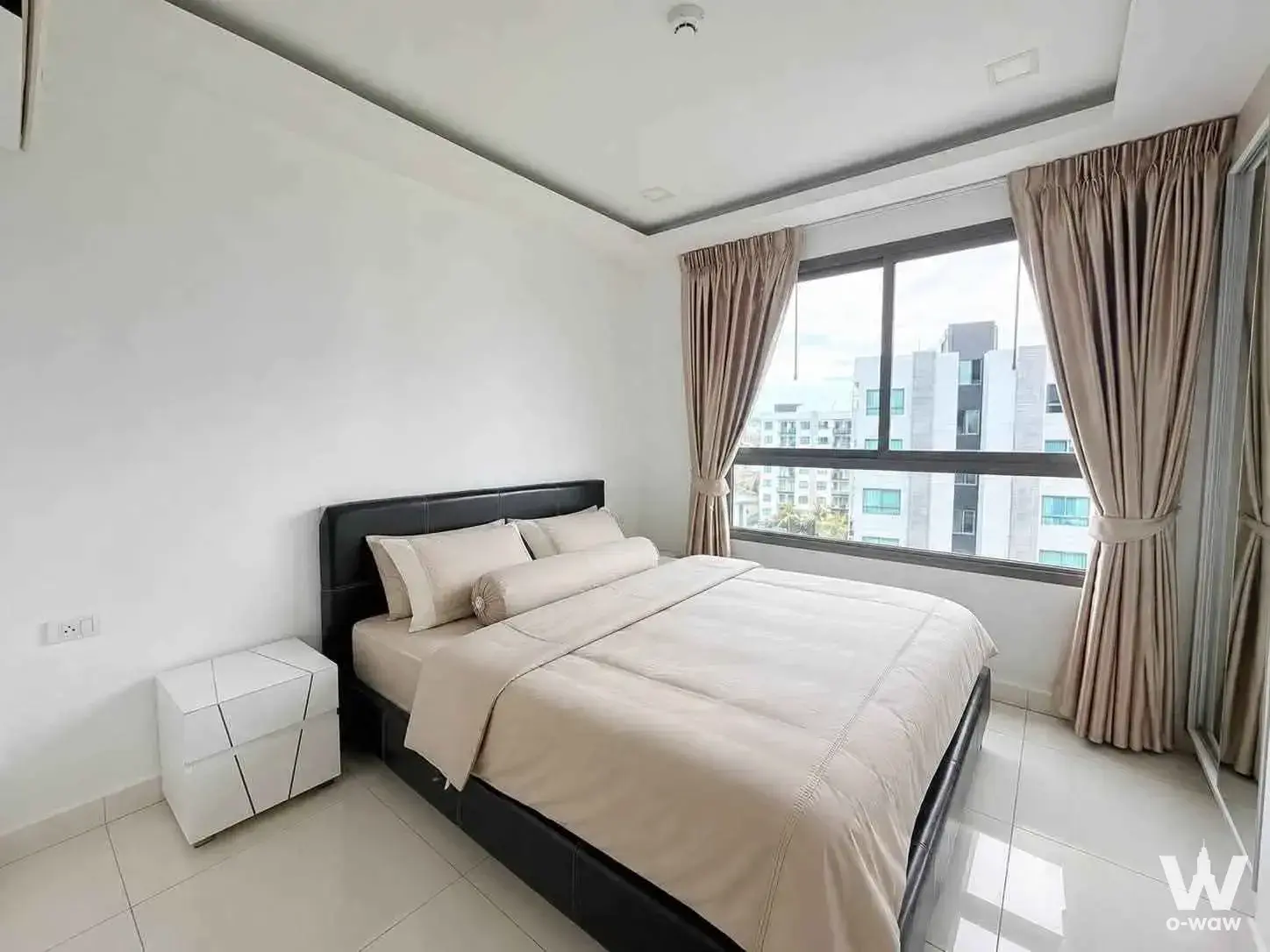 Arcadia Beach Resort 2-bed condo bedroom with black leather bed frame and city view