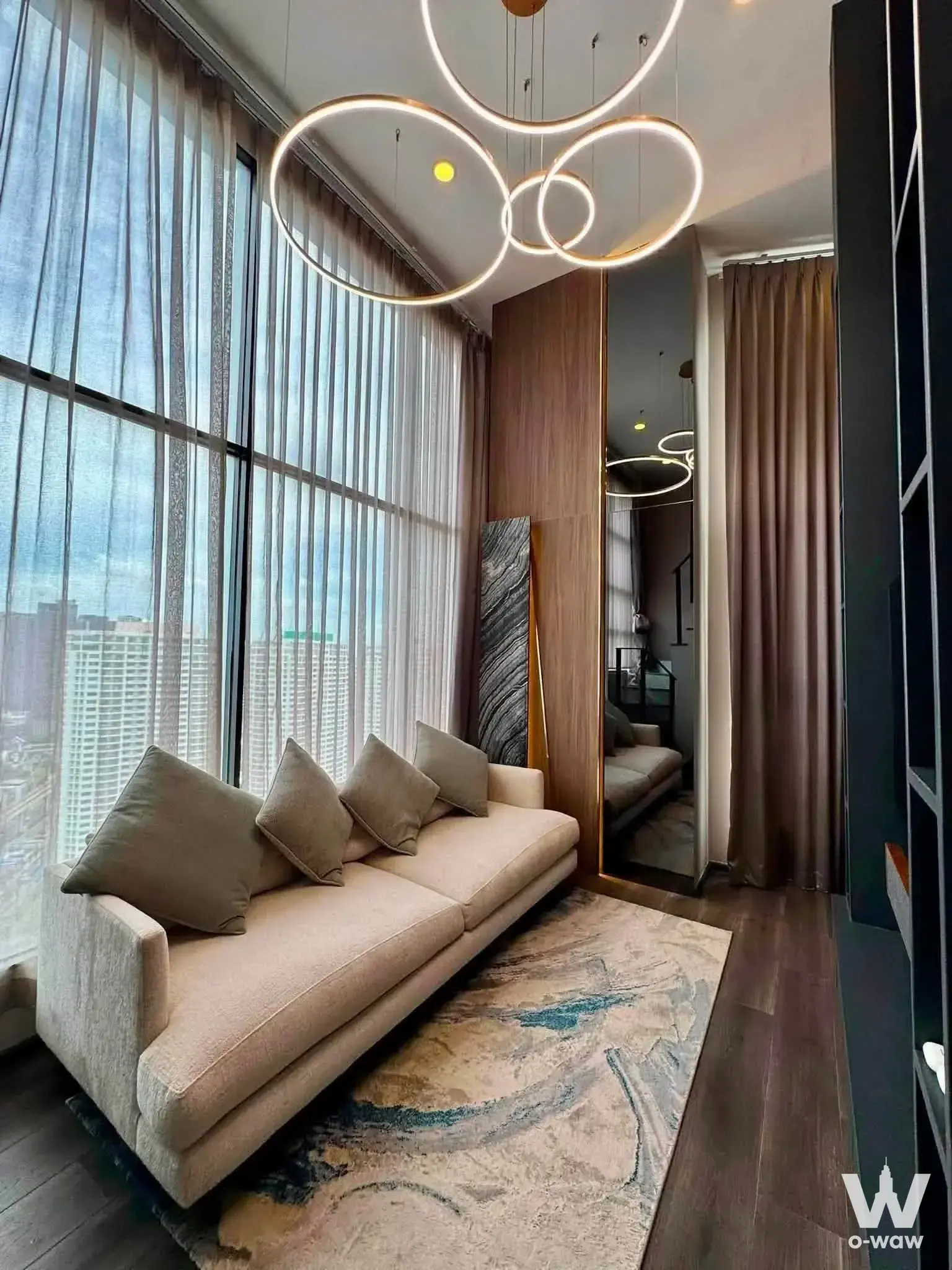 Luxury living room at KnightsBridge Space Ratchayothin with gold chandelier and city view