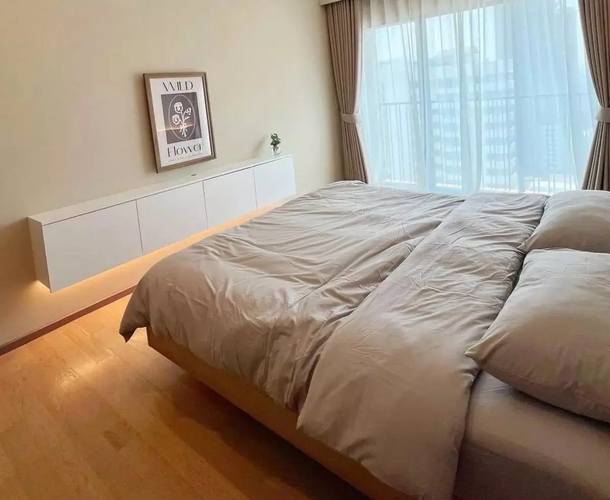 Queen bed and floating sideboard in this 1-bed condo for rent at Noble Refine with city views