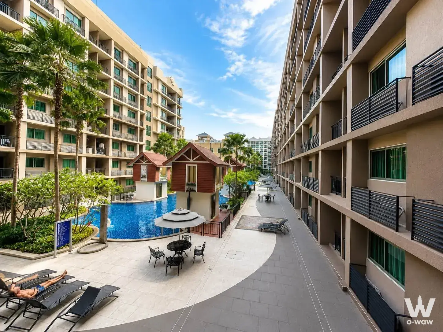 Resort-style pool courtyard with palm trees and lounge chairs at Arcadia Beach Continental