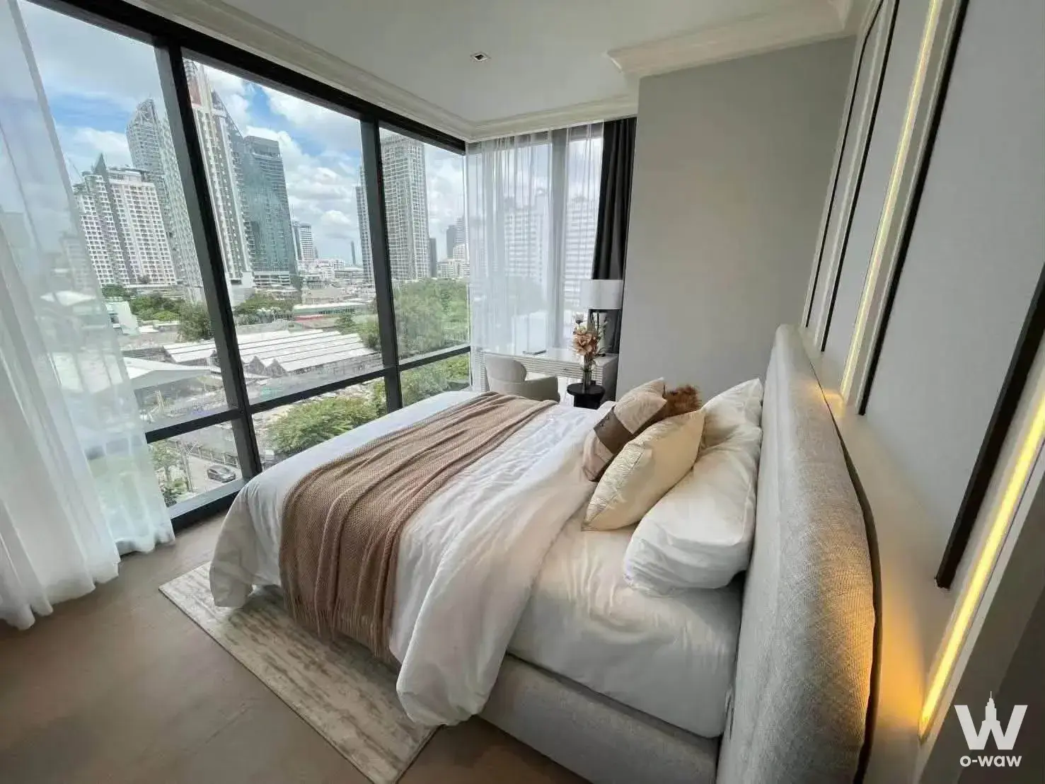 King bed bedroom in Ashton Silom condo featuring corner windows and city skyline view