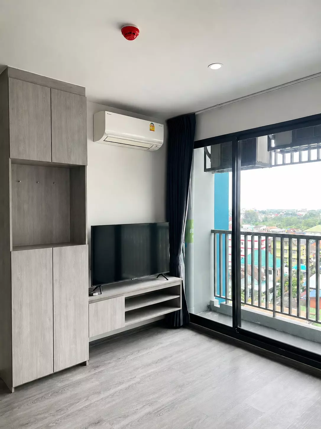 Unfurnished living room in The Origin E22 Station with built-in grey cabinets and balcony access