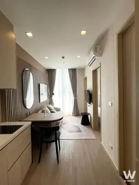 Furnished 1-bed condo in Noble State 39 featuring a slat wood accent wall and light flooring