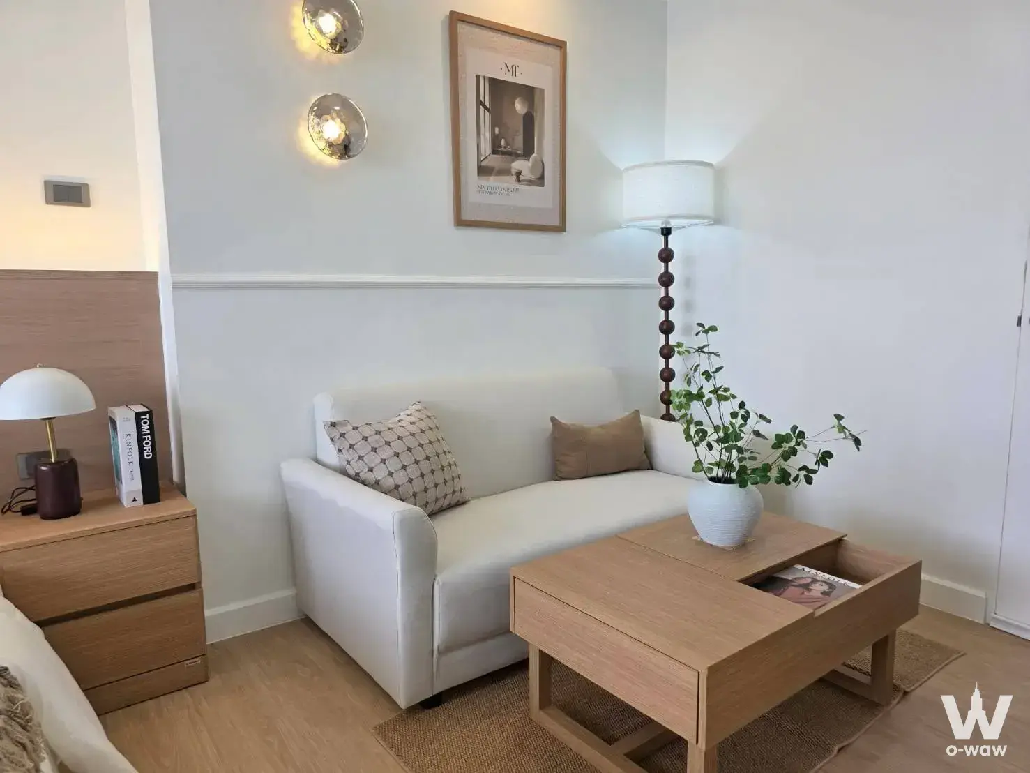 Lumpini Condotown Ramintra studio condo has a sofa, coffee table, and warm sconces