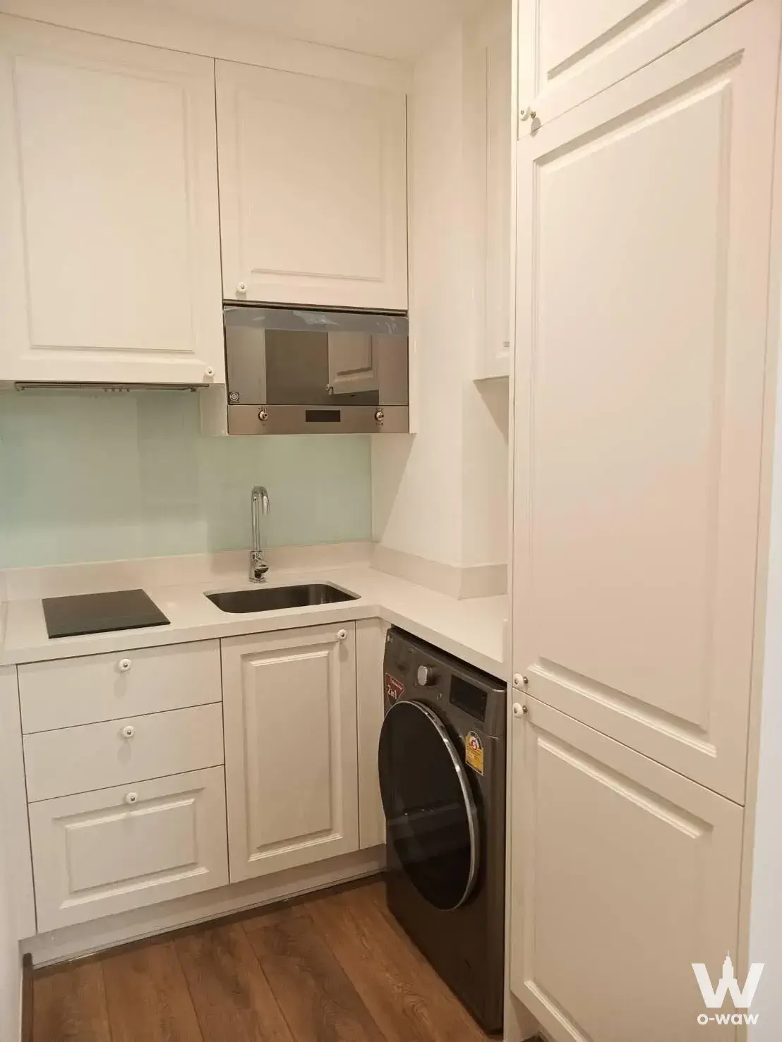 Noble BE33 kitchenette with mint backsplash, white cabinetry, and compact layout