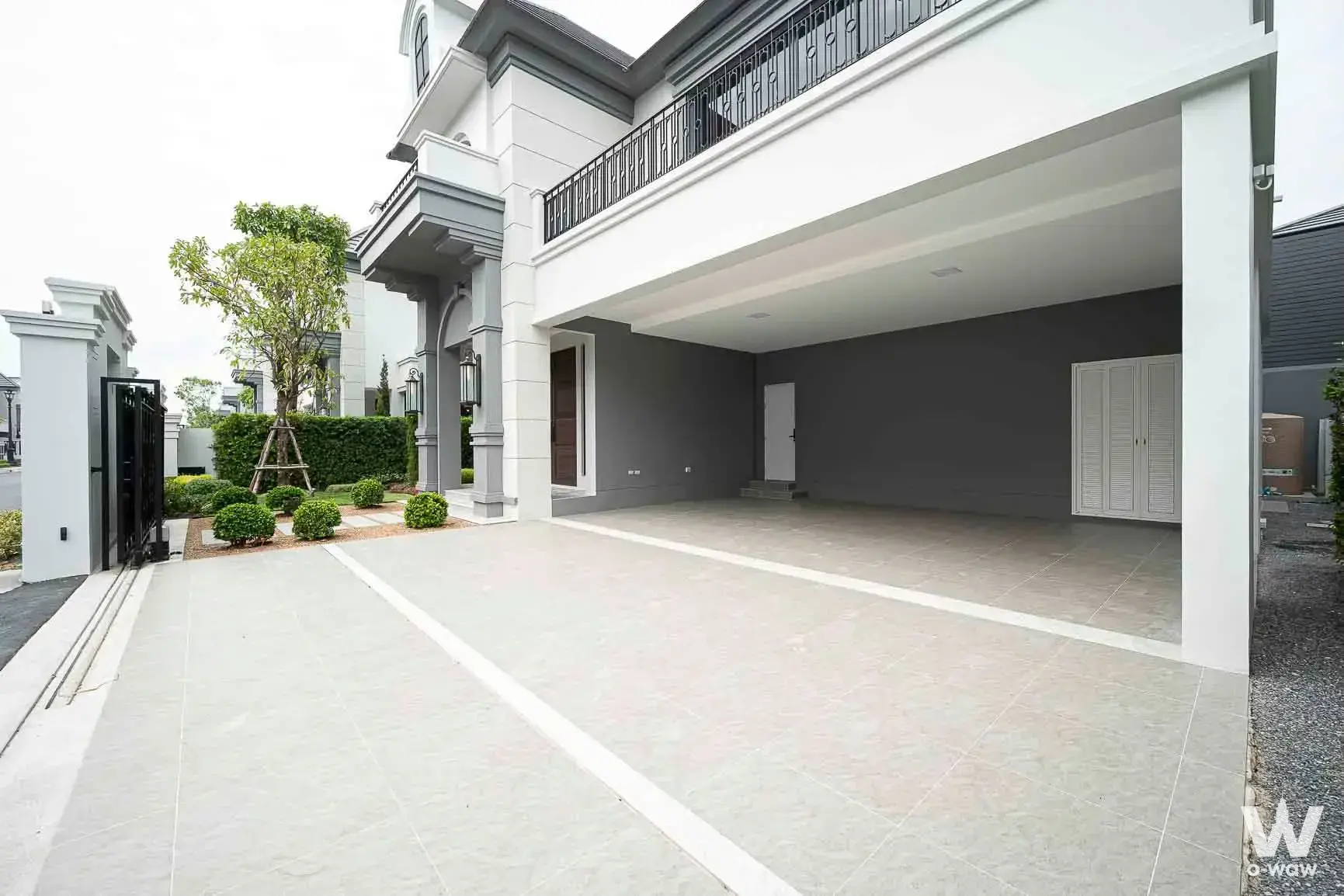 Modern two-story house for sale in Narasiri Phahol-Watcharapol featuring a grey stone facade and tiled driveway