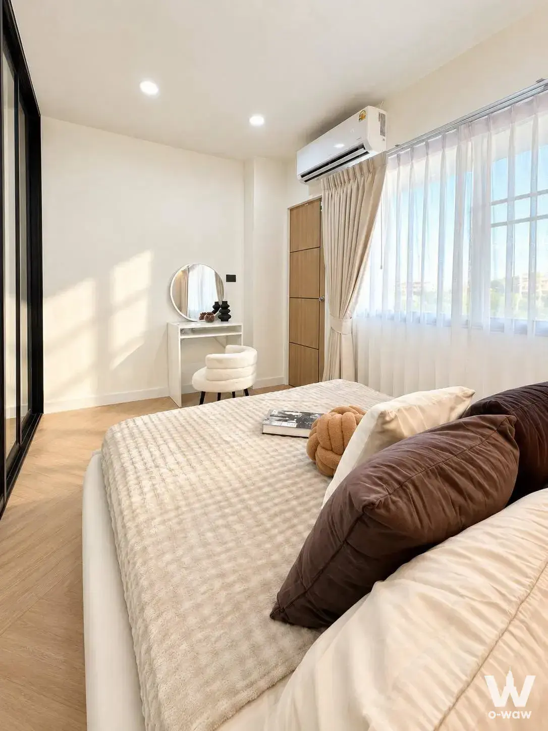 Bright bedroom in a 1-bed condo for sale at Ratchada Prestige Ladprao 48 has a queen bed and light wood wardrobe