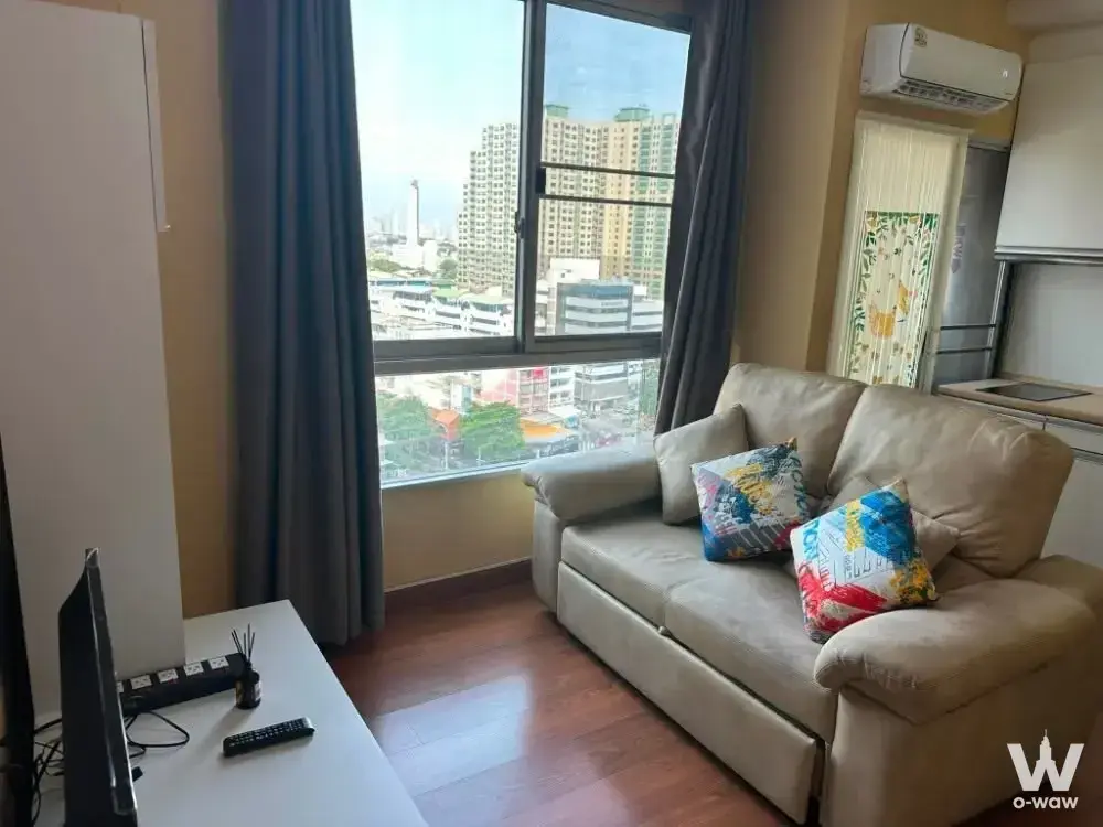 Living room with beige sofa and city view in The Parkland Ratchada-Tha Phra condo