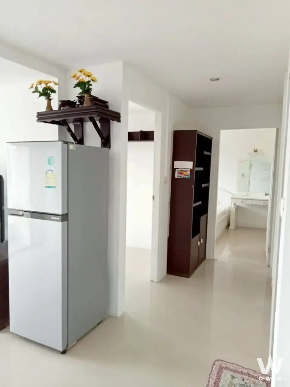 Bright hallway with glossy cream tiles and dark wood storage in this Tawanna Residence 2 condo for sale