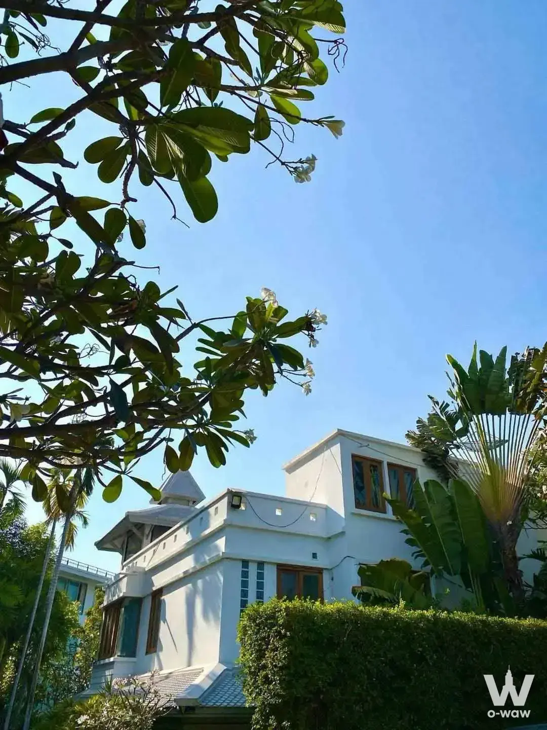 White two-story villa exterior for rent at The Sanctuary Wong Amat with tropical garden landscaping under a clear blue sky