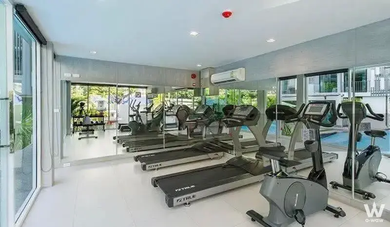 Modern gym with treadmills and pool view in a 2-bed Beyond Sukhumvit Condominium
