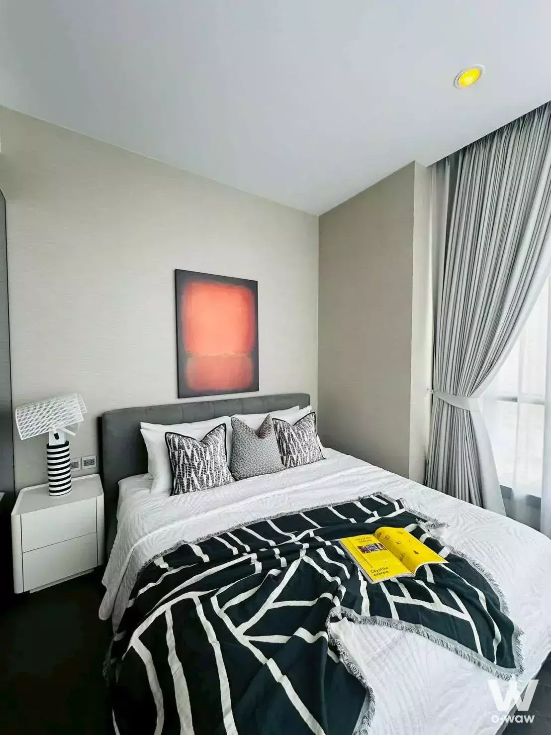 THE ESSE Sukhumvit 36 bedroom with queen bed, geometric throw and orange abstract art above the upholstered headboard