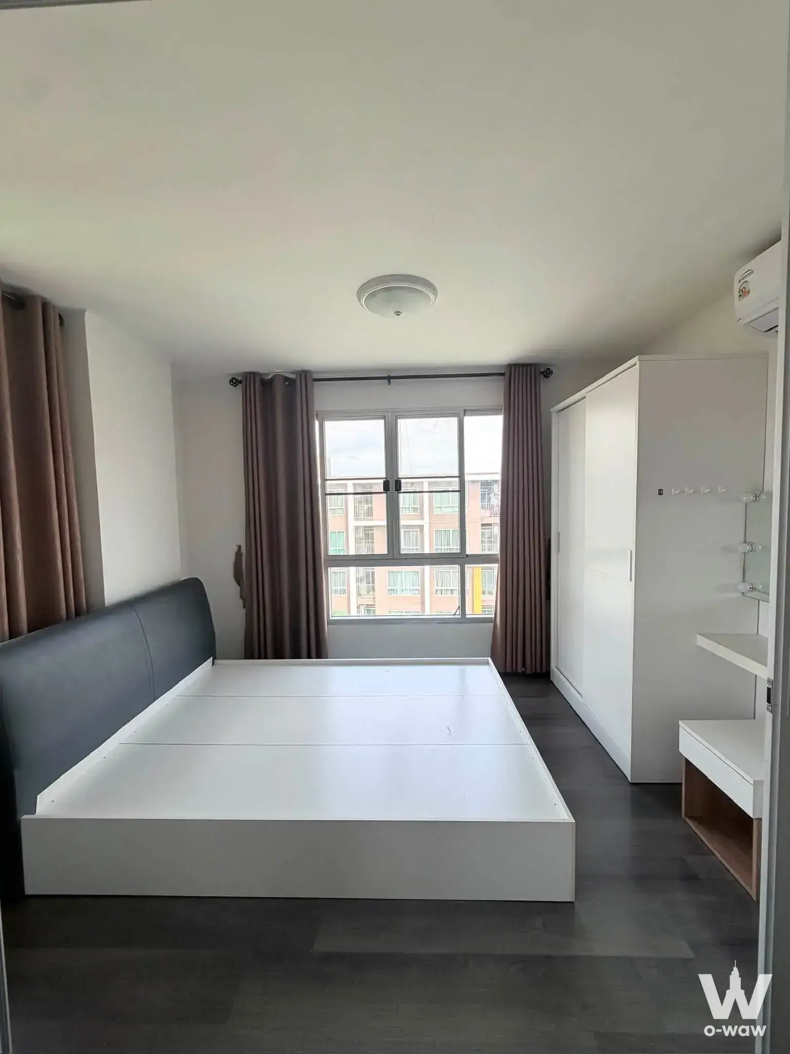 1-bed condo for sale in dcondo Campus Resort Bangsaen featuring a modern bedroom with white platform bed and dark-grey