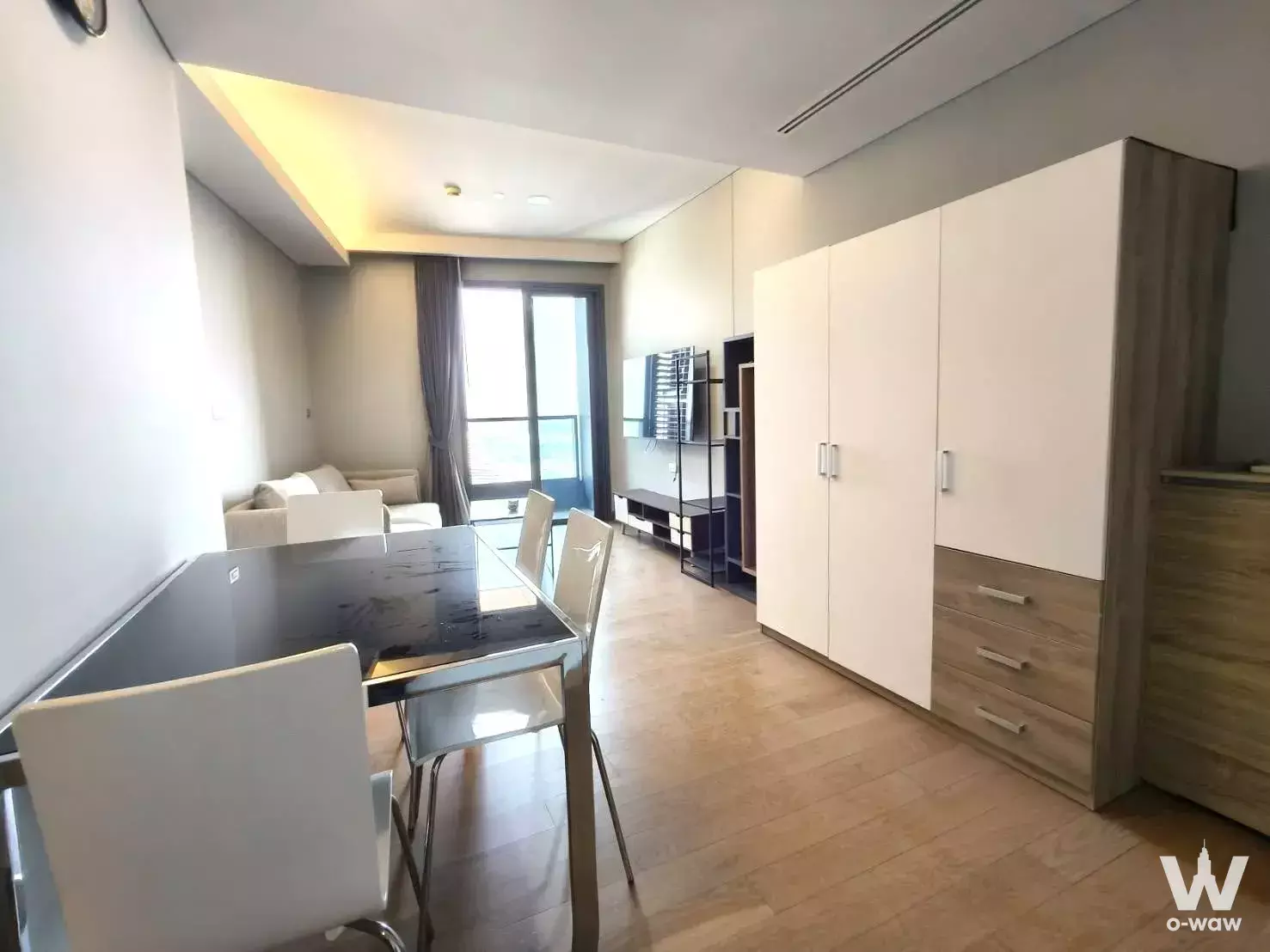 Dining area with glass table and wardrobe in a 2-bed unit for rent at The Lumpini 24
