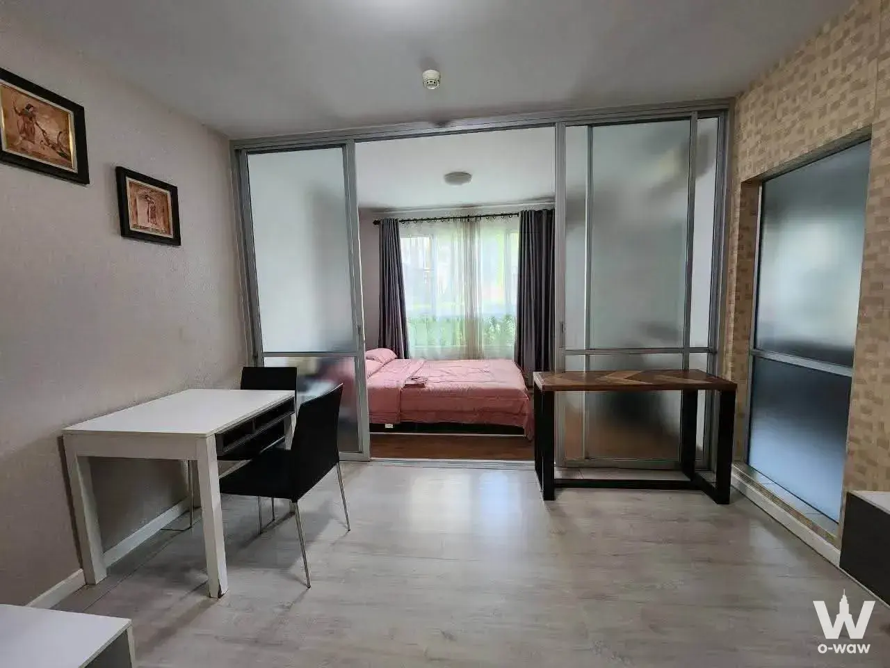 Studio condo in dcondo Sign Chiangmai with a white dining set, frosted glass partition, and bedroom visible through the