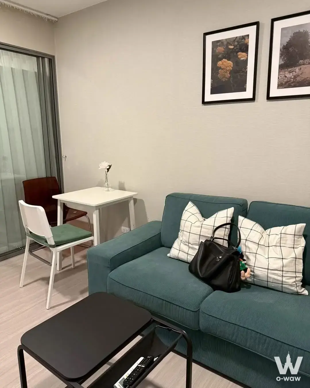 Teal sofa and dining nook in a furnished 1-bed condo for rent at Quintara Phume Sukhumvit 39