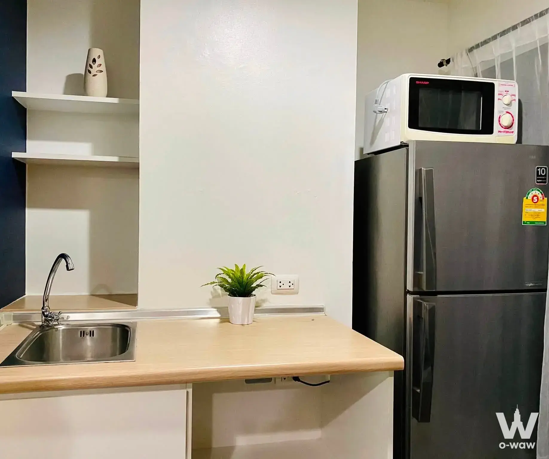Kitchenette in Lumpini Ville On Nut 46 featuring wood counter, stainless sink, fridge, and microwave