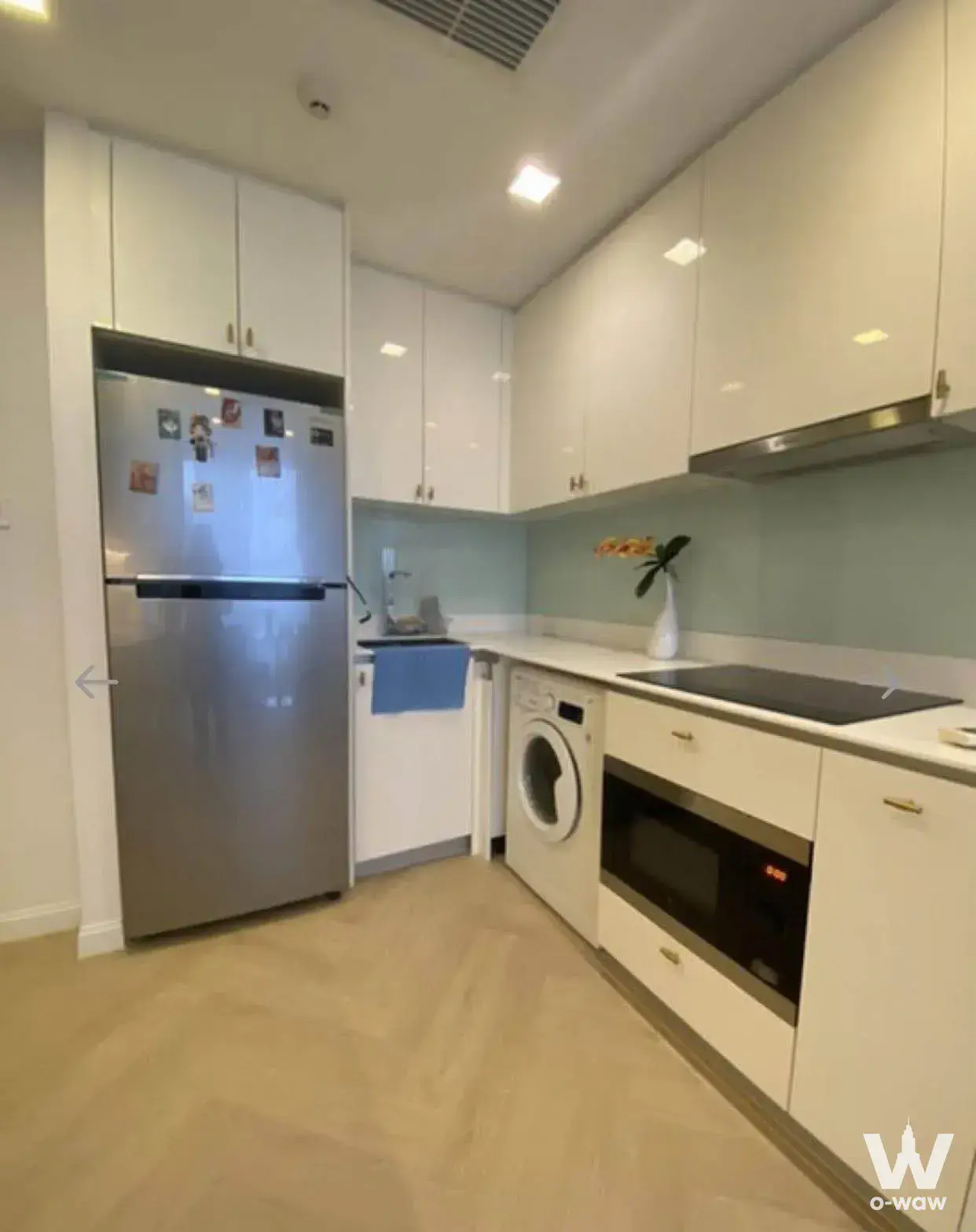 Fully furnished kitchen in HYDE Sukhumvit 11 featuring white quartz counters and stainless steel appliances