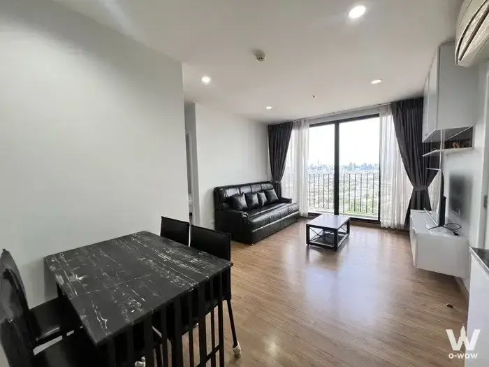 Black leather sofa and city skyline view in this 2-bed rental at The Tree Interchange