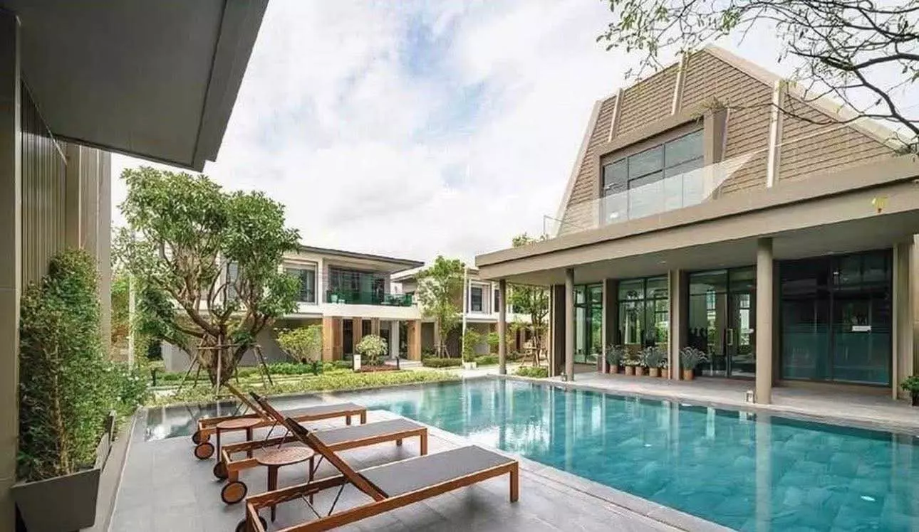 Resort-style pool with turquoise water and wooden loungers at Bangkok Boulevard Bangna KM.5